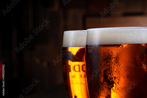a glass of foamy beer on a dark background
