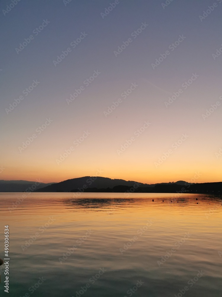 yellow, red sunset, lake, blue water, mountains