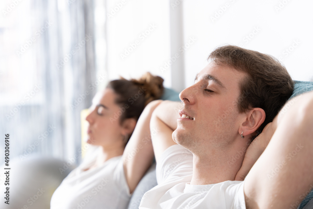 Man and woman resting with closed eyes on couch Man and woman resting with closed eyes on couch