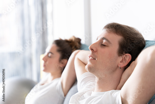 Man and woman resting with closed eyes on couch © Egoitz