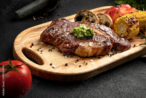 Bild auf Leinwand steak served on a wooden tray with grilled vegetables