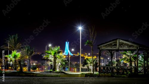 The Maqam Echahid, Martyrs' Memorial , low angle view from sablettes promenade park by night. Palm trees, wood cabane, lamp and dark sky with stars. © Slimoche