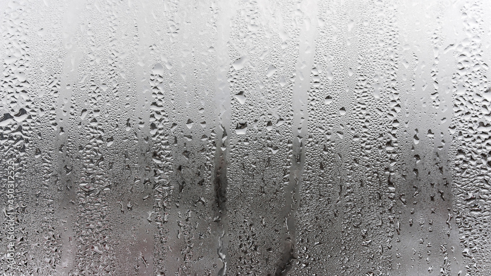 Fototapeta premium Texture of a drop of rain on a glass wet transparent background, humidity and foggy blank