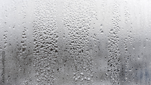 Texture of the rain on the glass, steamy window with water drops made in dull day