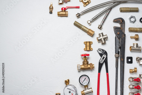 Plumbing equpment parts and wrenches on the white flat lay background with copy space. Pipeline parts.