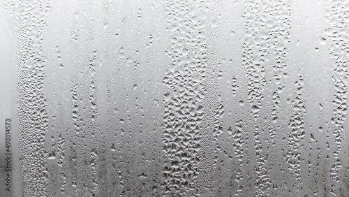 Close up for misted glass with droplets of water draining down. Dripping Condensation, Water Drops Background Rain drop Condensation Texture
