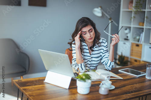 Thoughtful anxious business woman looking away thinking solving problem at work, worried serious young woman concerned make difficult decision lost in thought reflecting sit with laptop