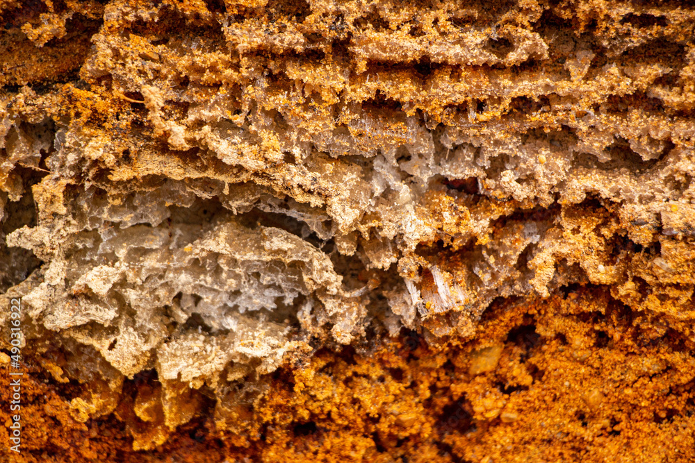 Textural sand, with relief surface, multi-colored layers and different in size of granules, in outdoor sand career, after mining ore and sand for construction. Textural sand, with relief surface, multi-colored layers and different in size of granules, in outdoor sand career, after mining ore and sand for construction.