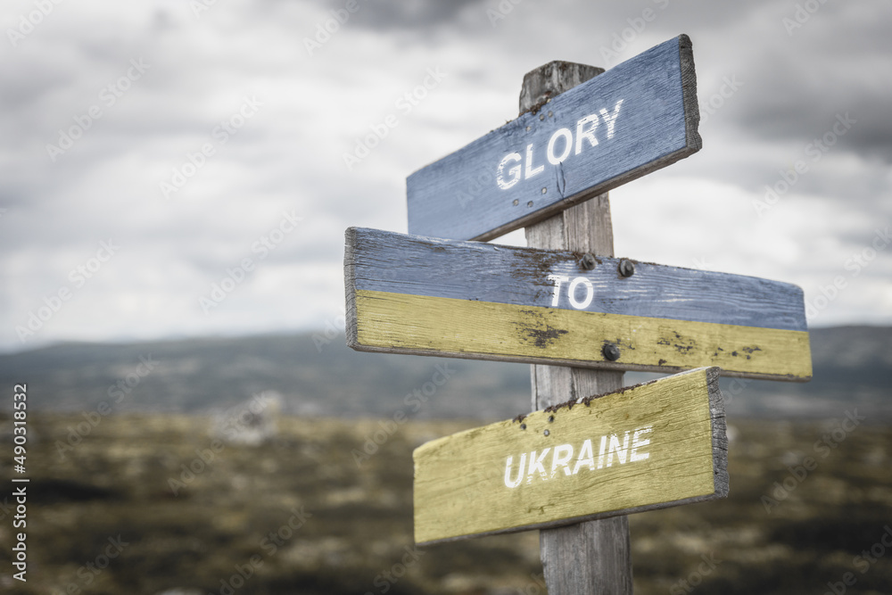 glory to ukraine text quote on wooden signpost outdoors, written on the ukranian flag.