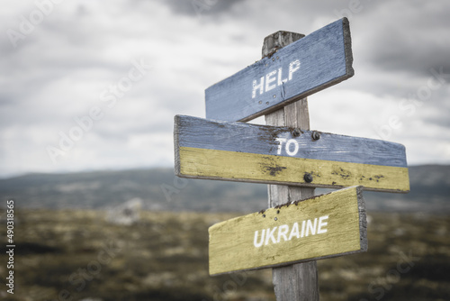 help to ukraine text quote on wooden signpost outdoors, written on the ukranian flag. photo