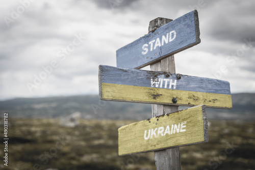 stand with ukraine text quote on wooden signpost outdoors  written on the ukranian flag. Peace and unity concept.