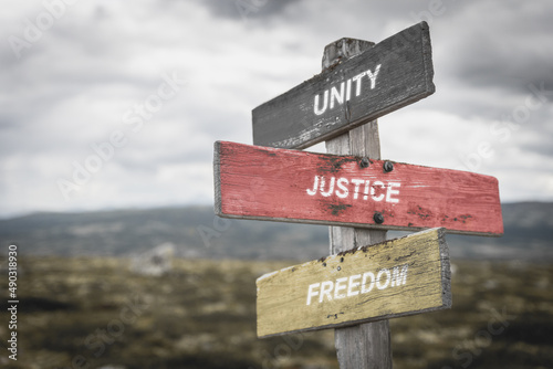 unity justice freedom text quote on german flag painted on wooden signpost outdoors in nature. To simulate the conflict in ukraine, europe.