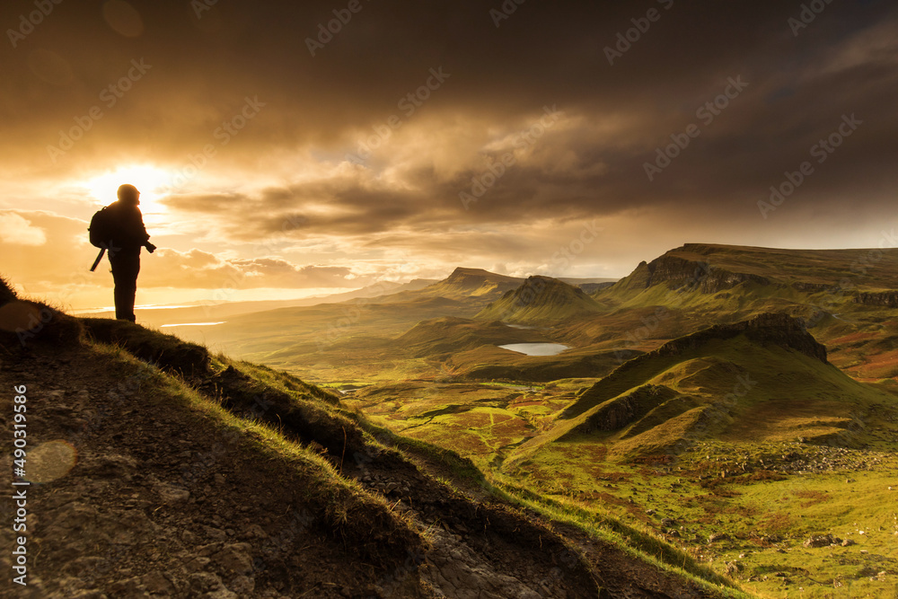 Scenic view of Quiraing mountains in Isle of Skye, Scottish highlands, United Kingdom. Sunrise time with colourful an rayini clouds in background.