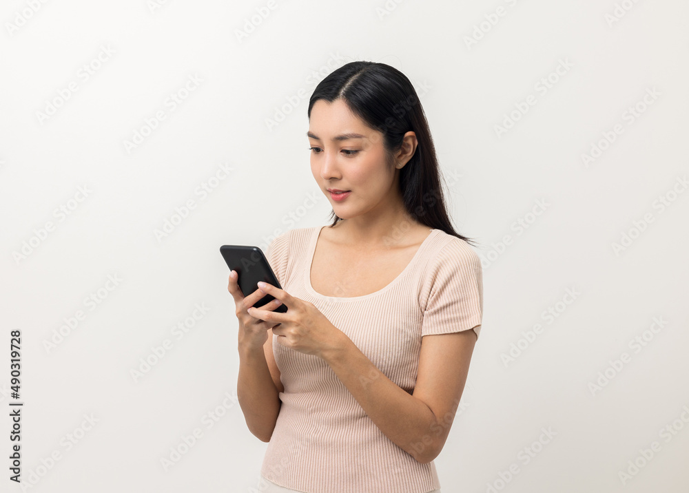 Excited Beautiful young asian woman using smartphone mobile standing on isolated white background. Playing game on smartphone winning victory moment. Very happy enjoy and fun relax time Excited Beautiful young asian woman using smartphone mobile standing on isolated white background. Playing game on smartphone winning victory moment. Very happy enjoy and fun relax time