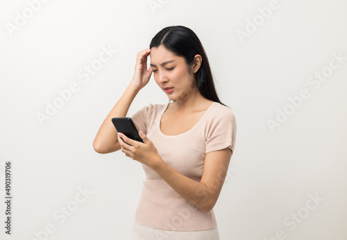 Young asian beautiful woman feeling upset looking at smartphone screen.