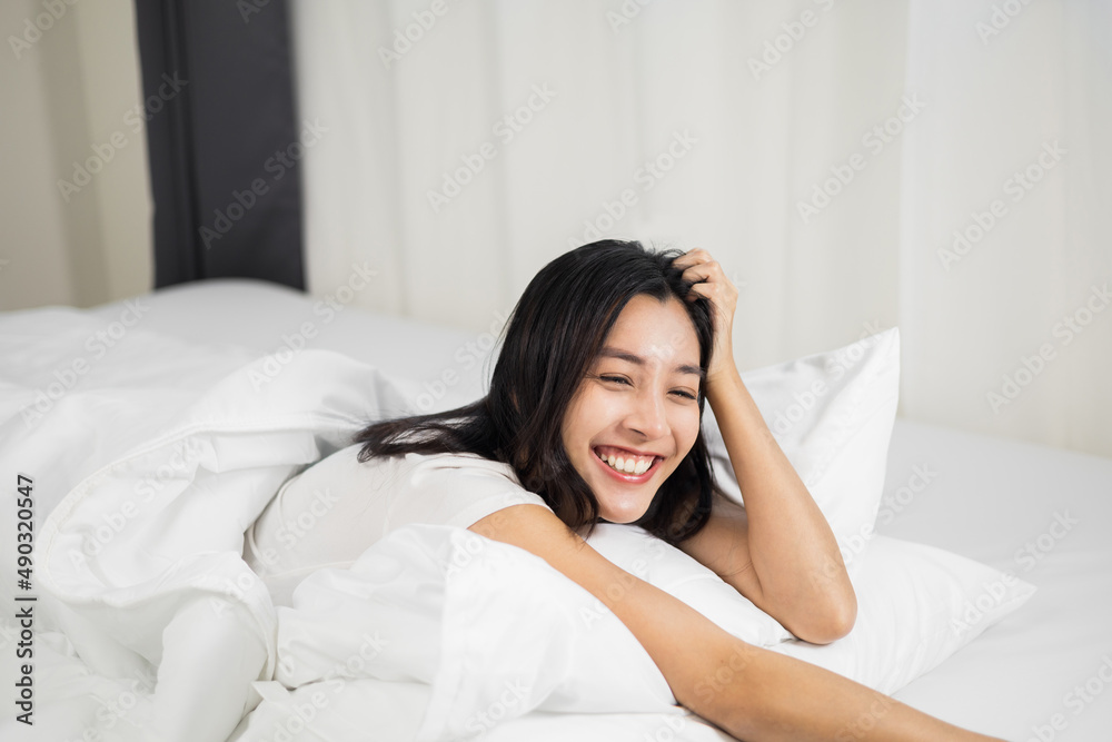 Young woman wake up before lying asleep enjoying healthy in the morning. Beautiful asian woman sleeping well in comfortable cozy fresh bed on soft pillow white linen. Young woman wake up before lying asleep enjoying healthy in the morning. Beautiful asian woman sleeping well in comfortable cozy fresh bed on soft pillow white linen.