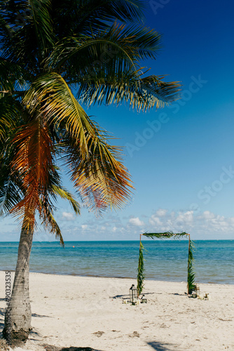 Wedding arch on a white sand beach Palm trees Sea and white sand beach wedding arch by the sea ready for the ceremony Wedding arch decorated with flowers for beach ceremony against the sea landscape