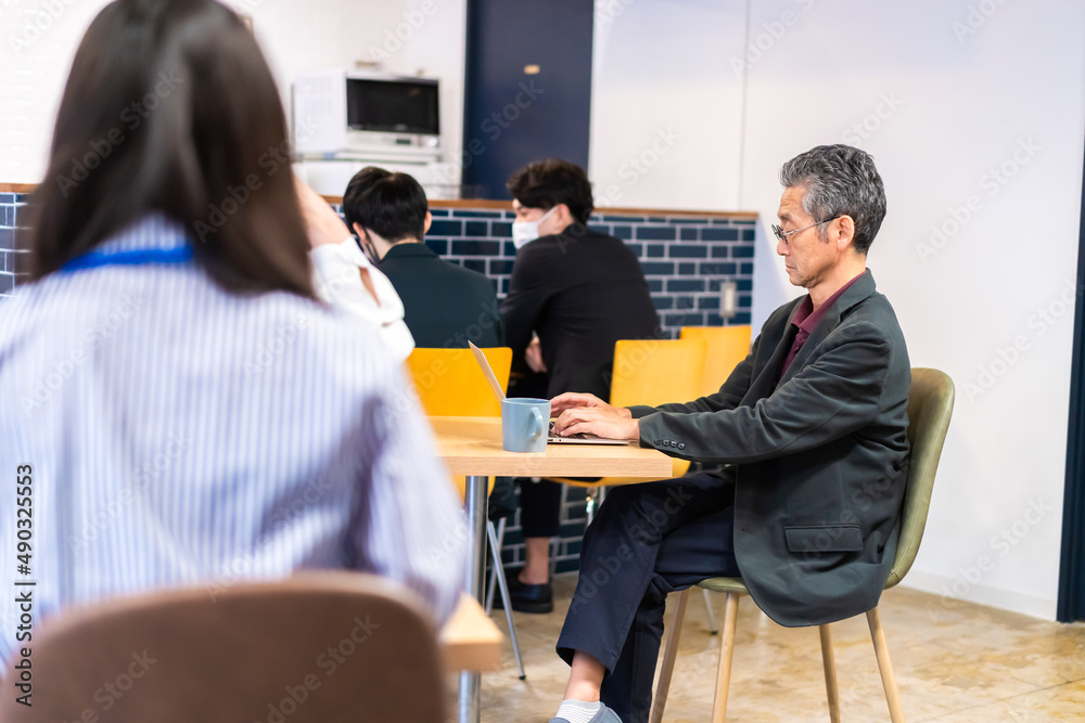 カフェで仕事をする中年男性 カフェで仕事をする中年男性