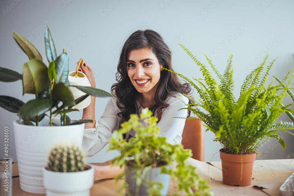 Playful woman gardening in home. Growing plants at home. Plant parent concept woman cultivating home plants. Woman Caring for House Plant. Female Care for Her Plant Playful woman gardening in home. Growing plants at home. Plant parent concept woman cultivating home plants. Woman Caring for House Plant. Female Care for Her Plant