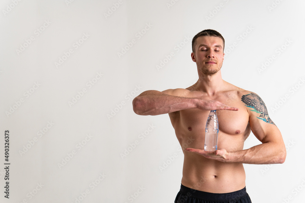 Male drink-water fitness is pumped with a towel on a white background isolated fit body, water sport adult guy, background cardio. Strength protein perfect, tired one muscle