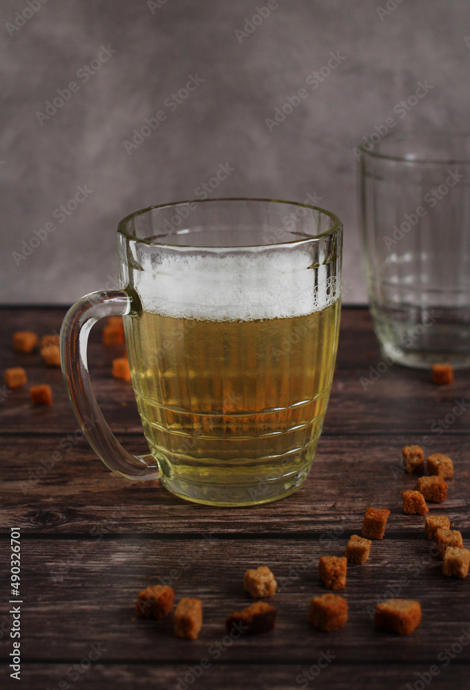 light beer in a glass mug with crackers on a dark background light beer in a glass mug with crackers on a dark background