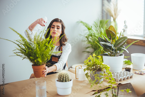Konstfotografi Young businesswoman sprays plants in flowerpots