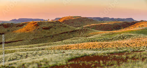 Panorama image of a semi-desert landscape with hills and table mountains in Millstream Chichester National Park at sunset, Pilbara, Western Australia photo