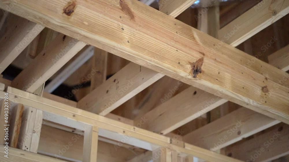 Home construction site showing rafters, framing, insulation and duct work in the ceiling Home construction site showing rafters, framing, insulation and duct work in the ceiling