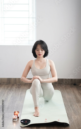 Asian girl doing yoga at home. Beautiful young asian woman practicing yoga 