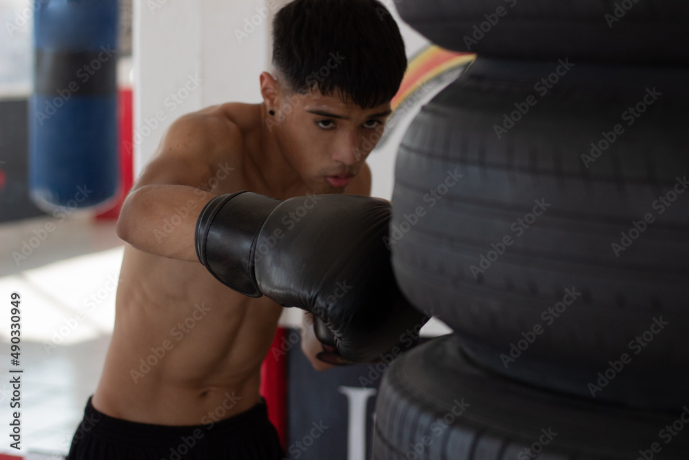 latin mexican boxer with gloves on training in the boxing gym