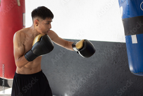 latin mexican boxer with gloves on training in the boxing gym © Carlos