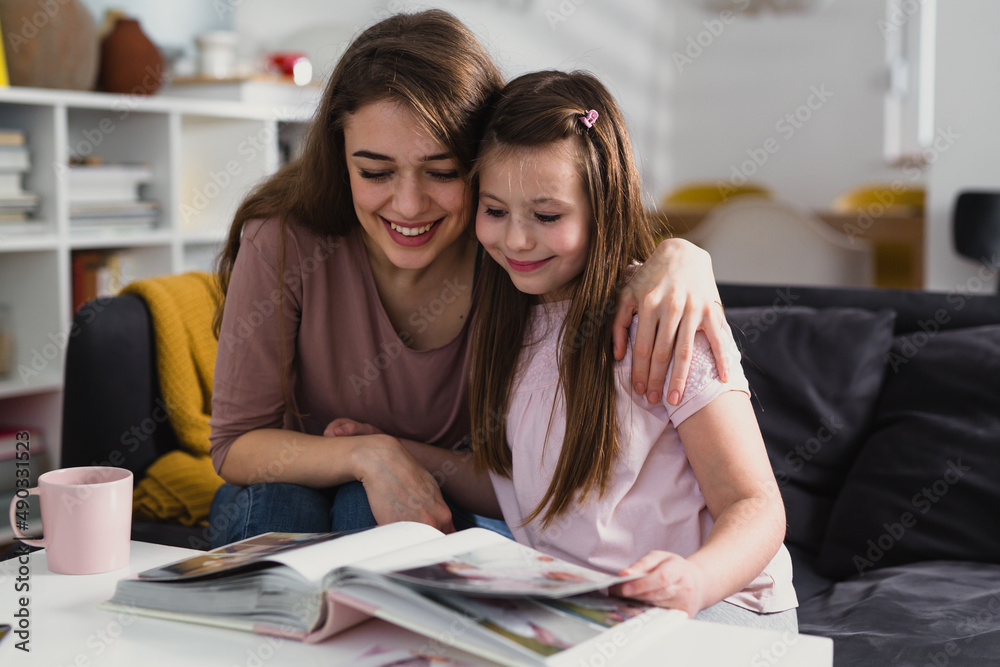 mother and daughter looking family photos at home mother and daughter looking family photos at home