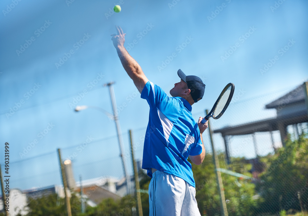 Blasting a serve. A male tennis player tossing the ball up into the air for  a service - Tennis. Stock Photo | Adobe Stock