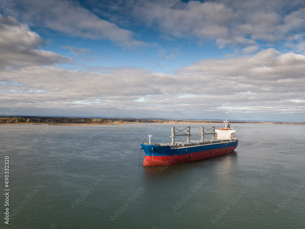 Fototapeta premium Cargo ship, bulk carrier, anchored near the Port of Montreal on the St. Lawrence River.