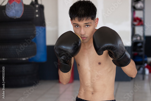 latin young boxer with raised fists posing for the camera