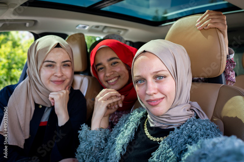 Muslim female friends enjoying road trip traveling at vacation in the car. High quality photo