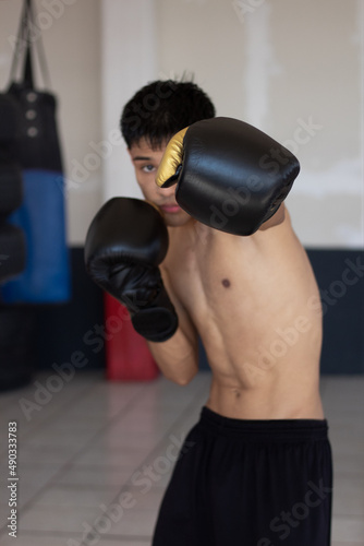 young latin boxer throwing a punch towards the camera © Carlos