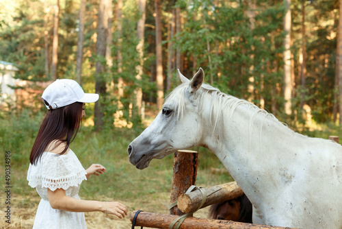 a girl in a pine forest on the background of horses