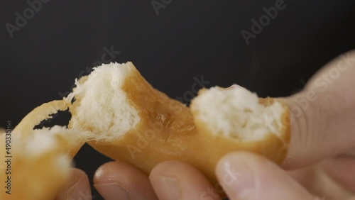 Close-up of hands breaking open a delicious homemade donut.