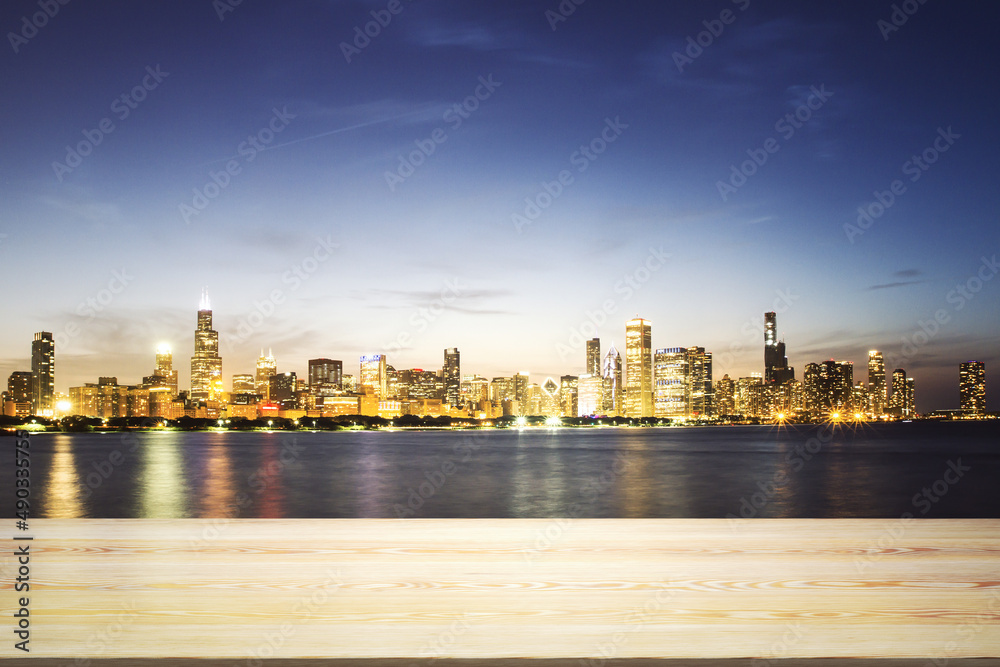 Fototapeta premium Empty table top made of wooden dies with Chicago city view at night on background, template