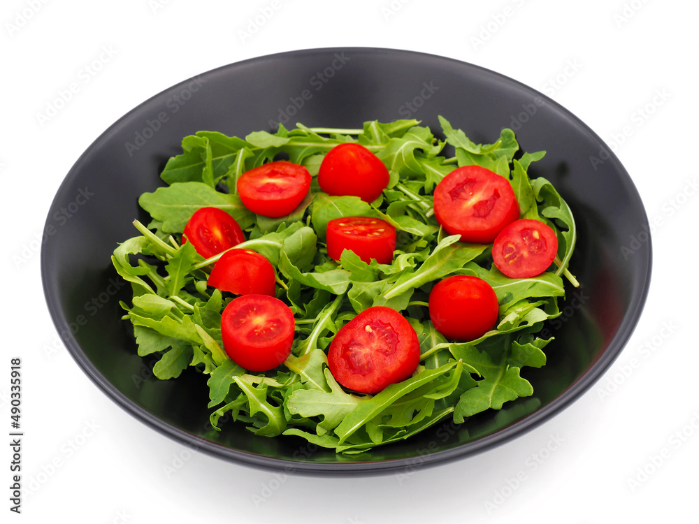 Green Arugula salad with red tomatoes isolated on white background Green Arugula salad with red tomatoes isolated on white background