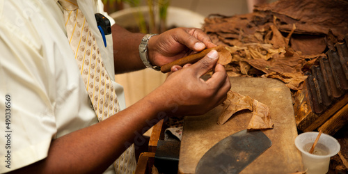 Hand making cigars from tobacco leaves, traditional product of Cuba. - banner size