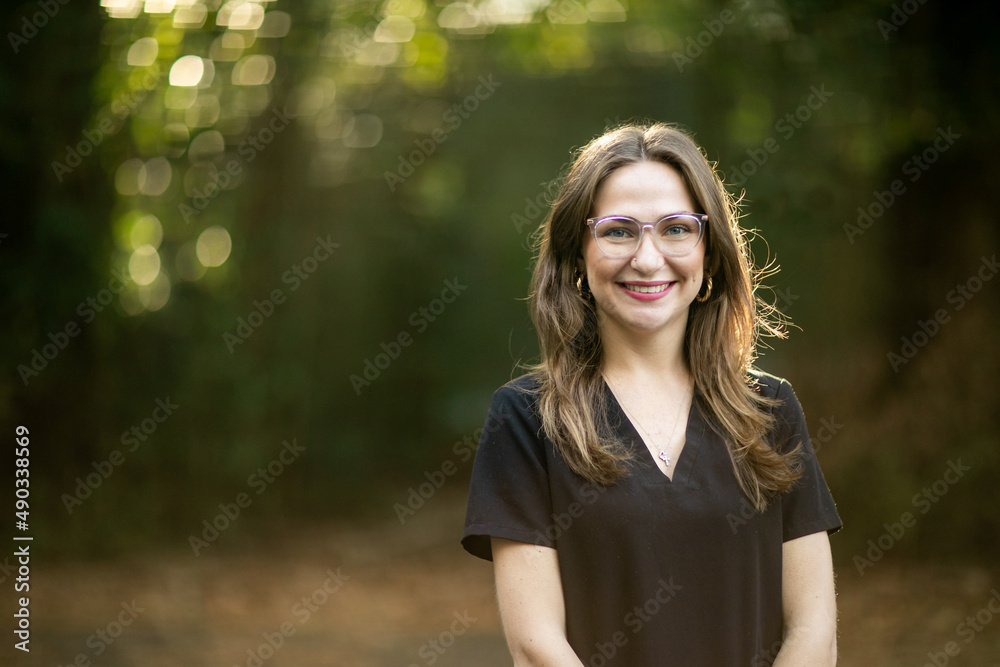 A medical professional with black scrubs outside in a natural background with copy space. A medical professional with black scrubs outside in a natural background with copy space.