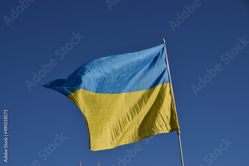The national flag of Ukraine with a clear blue sky background.