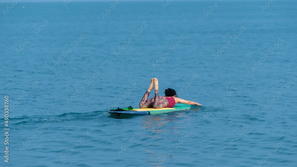 Asian yoga girl doing flexibility yoga exercise yoga on Sub-broad in sea. 