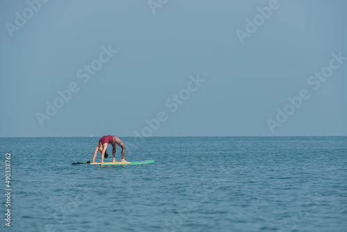 Asian yoga girl doing flexibility yoga exercise yoga on Sub-broad in sea. 