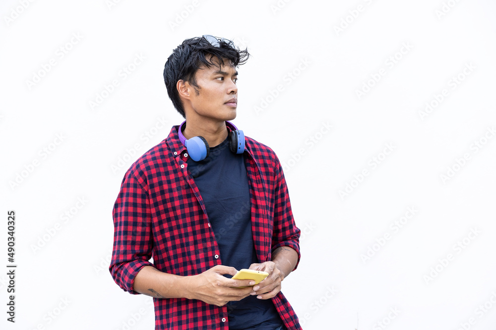 Isolated young asiatic man using mobile smart phone on a white background - Generation z and millennial people always connected Isolated young asiatic man using mobile smart phone on a white background - Generation z and millennial people always connected
