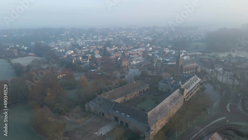 Aerial of Castle Wijnandsrade in Limburg, the Netherlands. The small town and church are in the background on a beautiful, misty winter morning photo