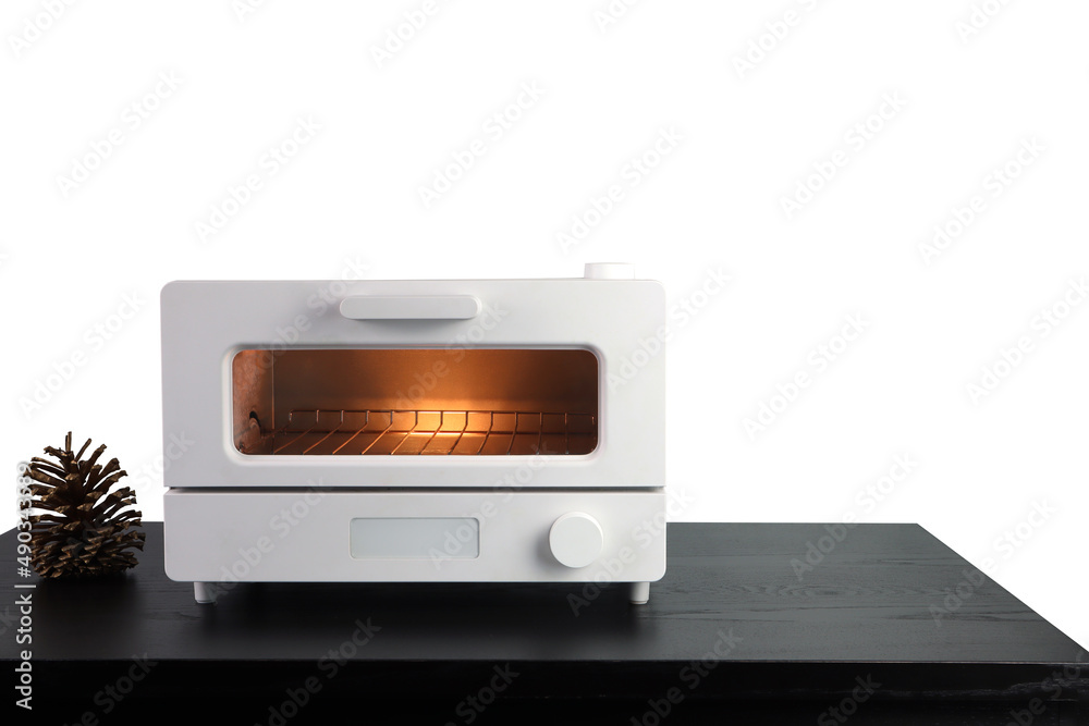 Fototapeta premium white modern design toaster oven is on the black wooden table with pinecone background of white wall of the kitchen (clipping path included)