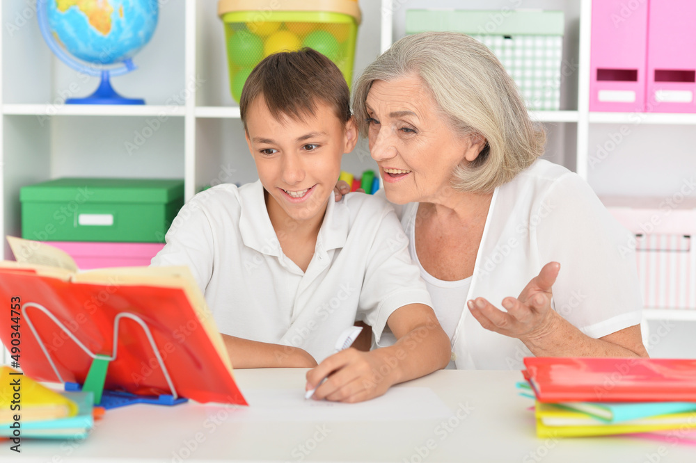 Granny with her grandson doing homework at home Granny with her grandson doing homework at home